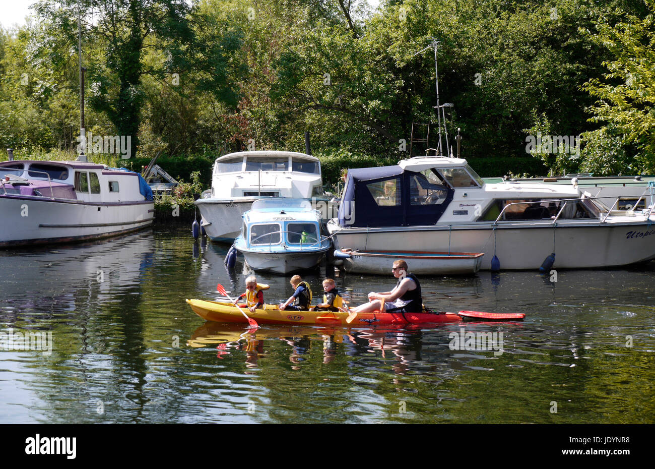 Famiglia di giovani ragazzi canoa sul Norfolk Broads con padre, fiume y vengono, a est di Norwich, Norfolk, Inghilterra, Regno Unito Foto Stock