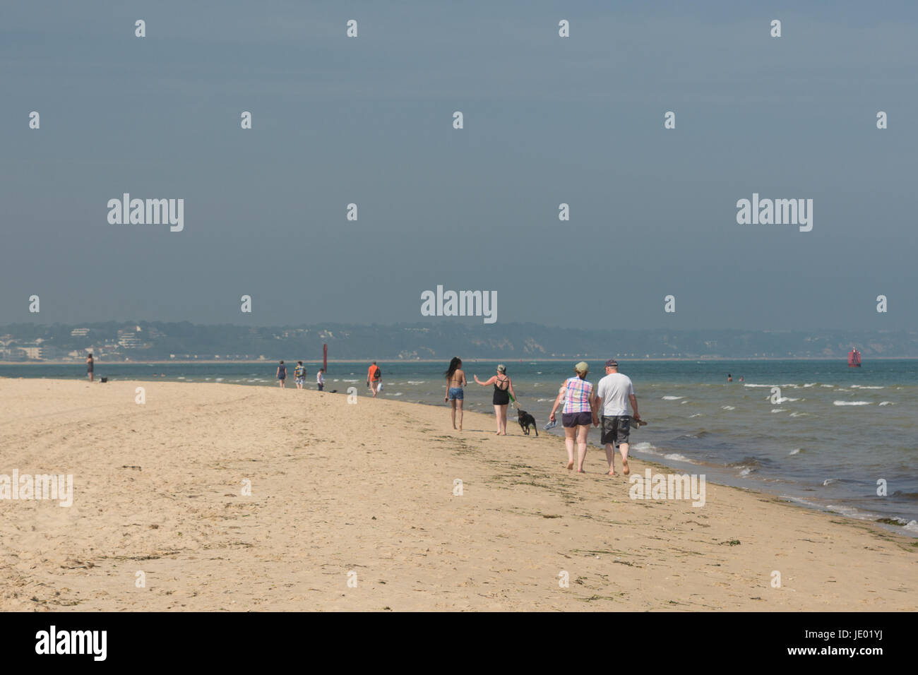 Studland Beach, Purbeck Peninsular, Dorset, Regno Unito, 21 giugno 2017. Su cosa potrebbe essere che l'ultimo giorno dell'attuale ondata di calore è una calda e soleggiata giornata sulla splendida spiaggia in sabbia di costa sud popolare con i turisti e gitanti uguali. Una brezza di mare moderato temperature a 24 gradi, a pochi gradi inferiore alla temperature record registrati nell'entroterra. La gente che camminava lungo il litorale. Foto Stock