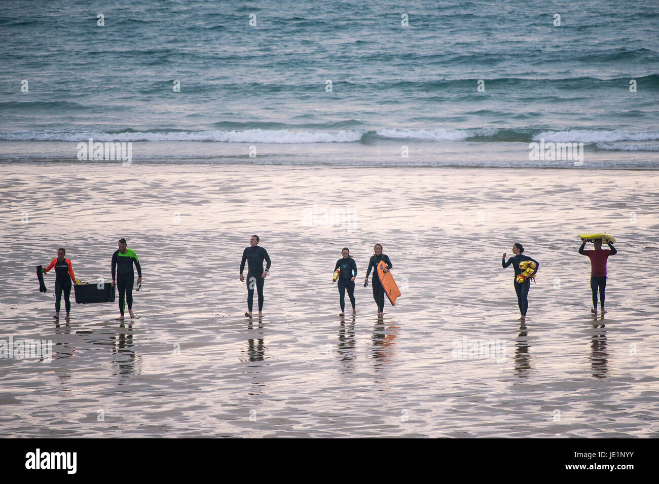 La gente che camminava sul Fistral Beach dopo un surf esercitazione di soccorso. Foto Stock