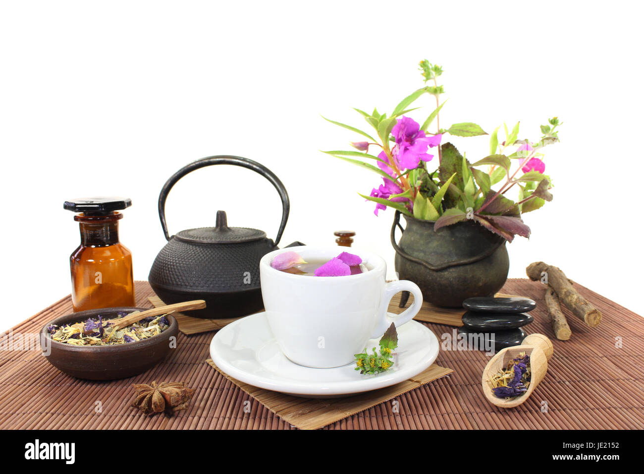 Chinesische Naturmedizin mit einer Tasse Tee und Blütenblättern sowie Kräuter Foto Stock