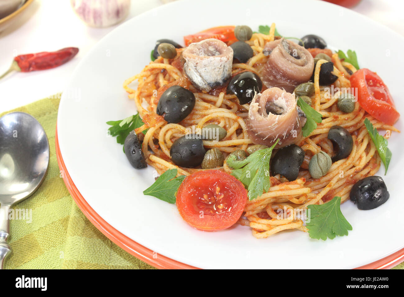 Spaghetti alla puttanesca mit Sardellen auf hellem Hintergrund Foto Stock