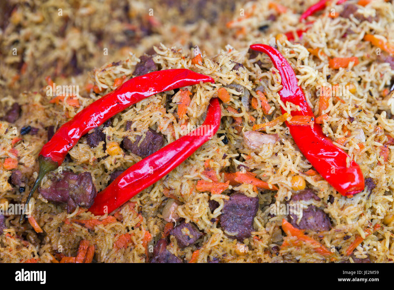 Pilaf con pezzi di carne e peperoncino closeup Foto Stock