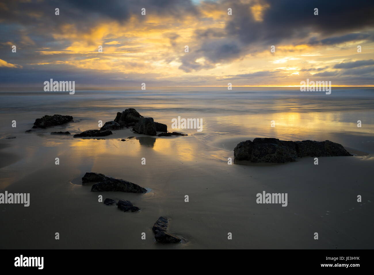 La bassa marea riflessioni su di una spiaggia di sabbia. Foto Stock