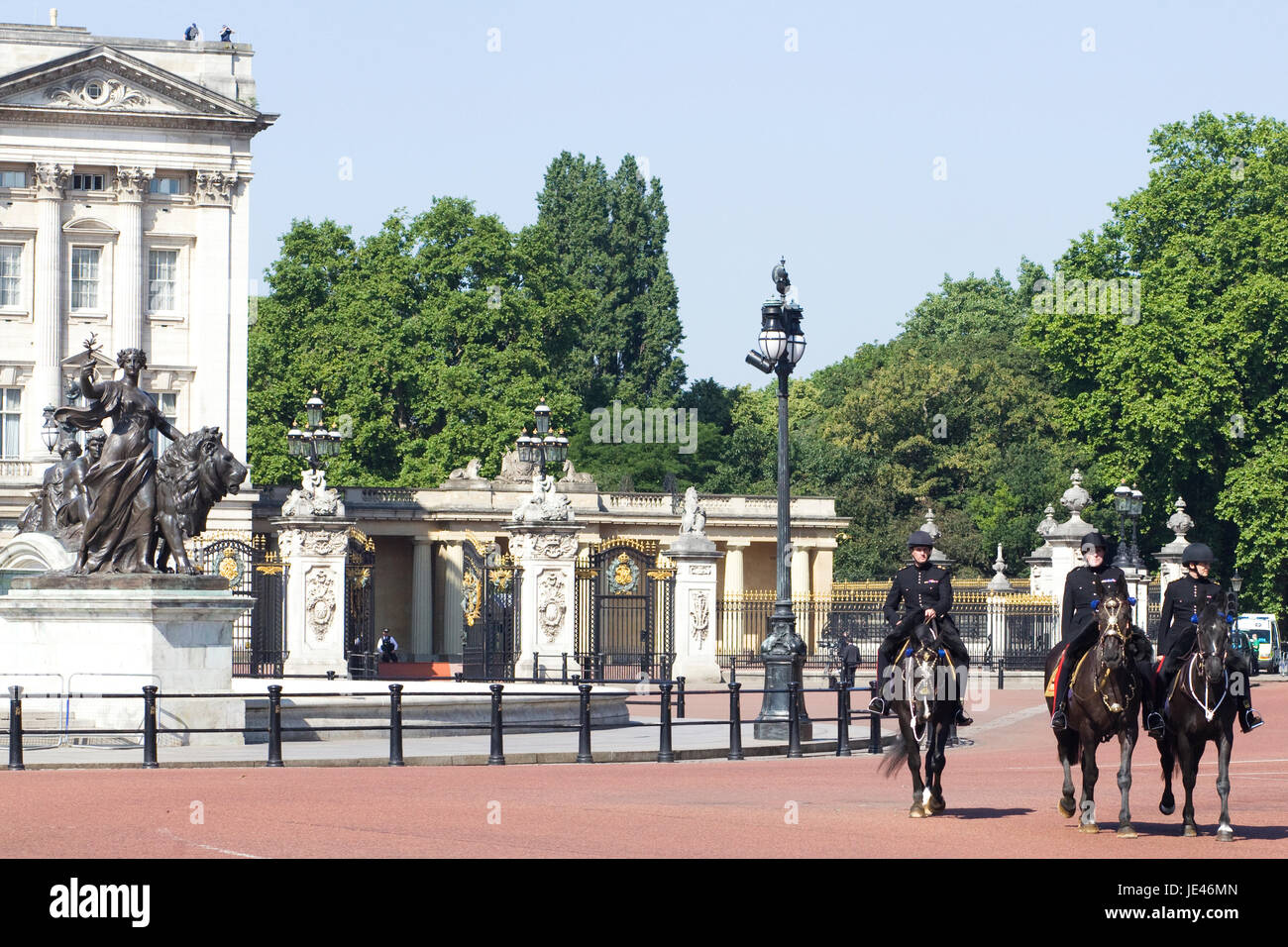 Famiglia di equitazione di cavalleria giù il mall passato la regina Victoria monumento Foto Stock