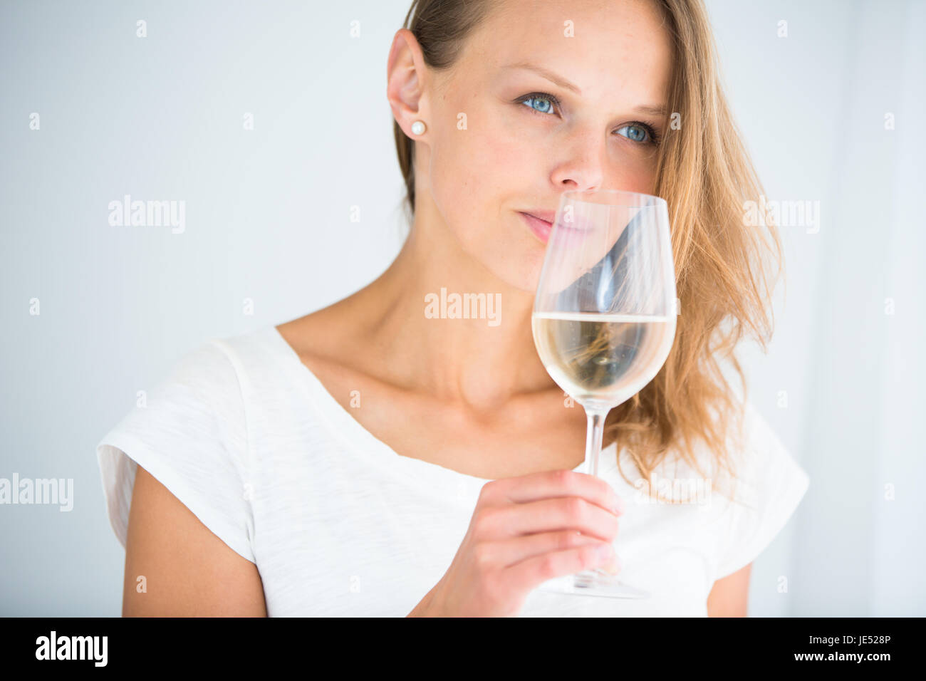 Stupendo giovane donna con un bicchiere di vino, odorando la deliziosa bevanda, assaporando ogni sorso (SHALLOW DOF; dai toni di colore immagine) Foto Stock
