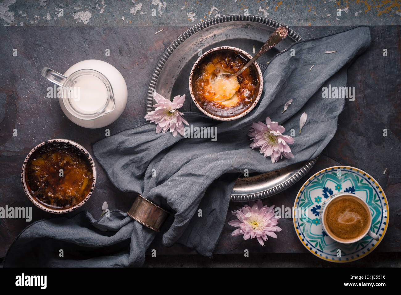 Creme brulee, caffè, fiori sul tavolo orizzontale Foto Stock