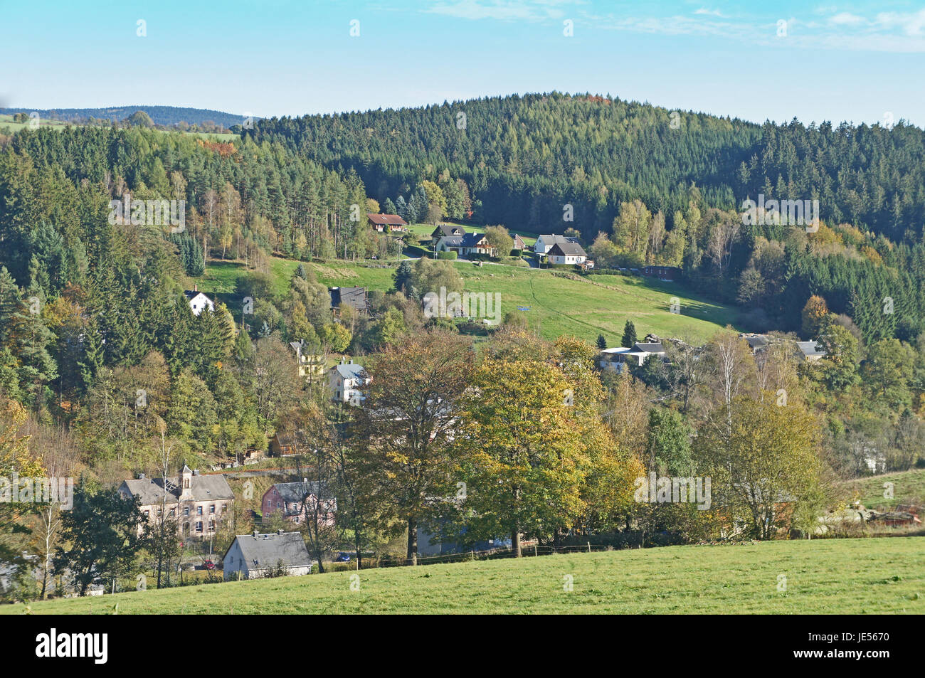 Kleines Dorf im Erzgebirge, Herbstlandschaft mit bunten Wäldern und versteckten Häusern Piccolo villaggio nei Monti metalliferi, autunno paesaggio con boschi variopinti e case di nascosto Foto Stock