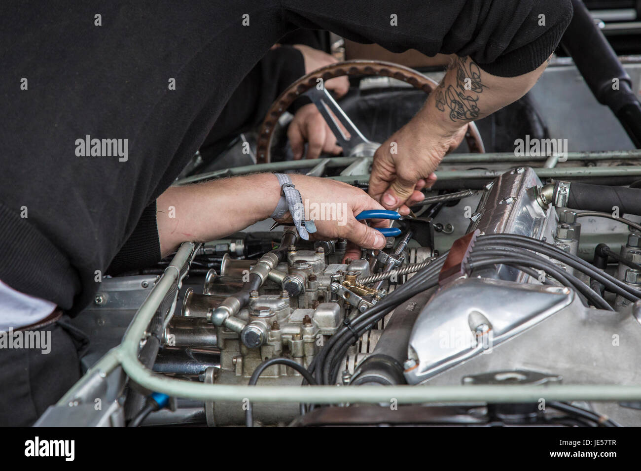 Meccanica in un duro lavoro preparando il loro motore per il Goodwood GRRC LXXV Assemblea dei Soci, Sussex, Regno Unito. Foto Stock
