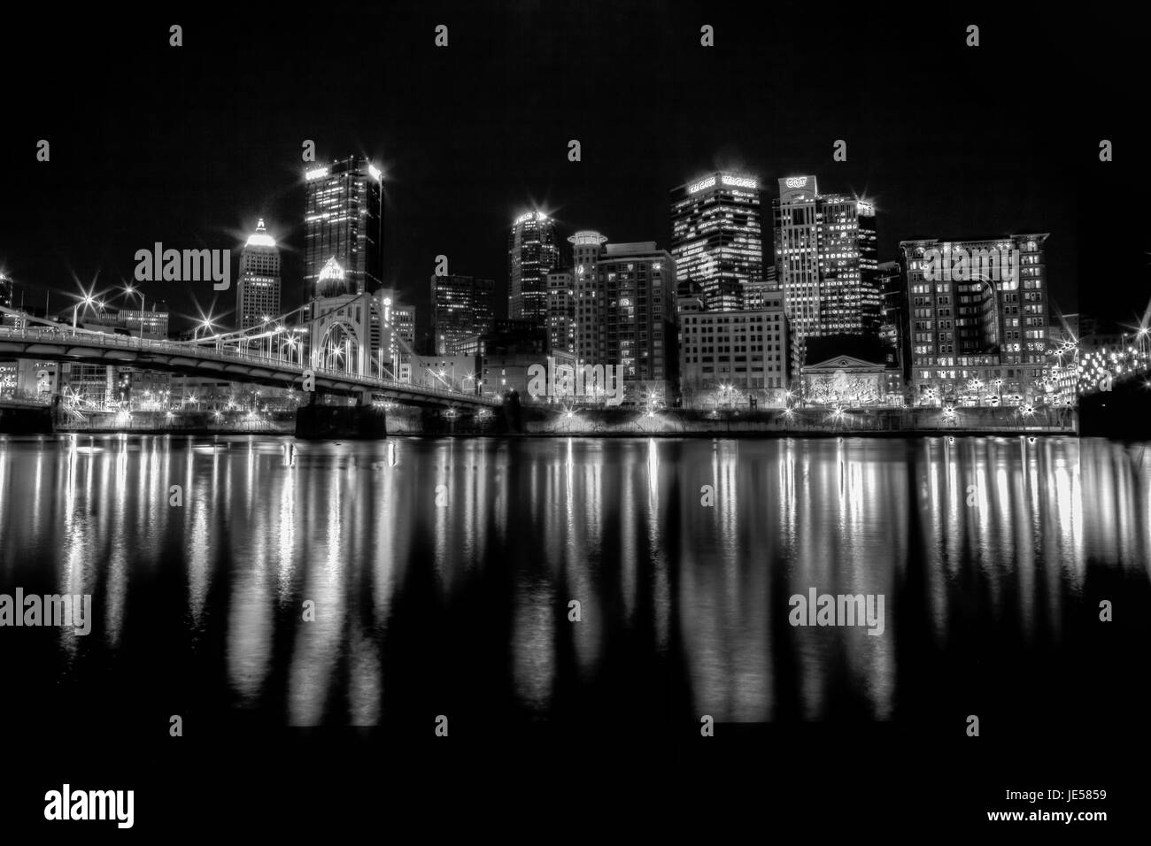 Foto in bianco e nero di Pittsburgh, Pennsylvania skyline notturno che si affaccia sul fiume Allegheny con Andy Warhol Bridge. Foto Stock