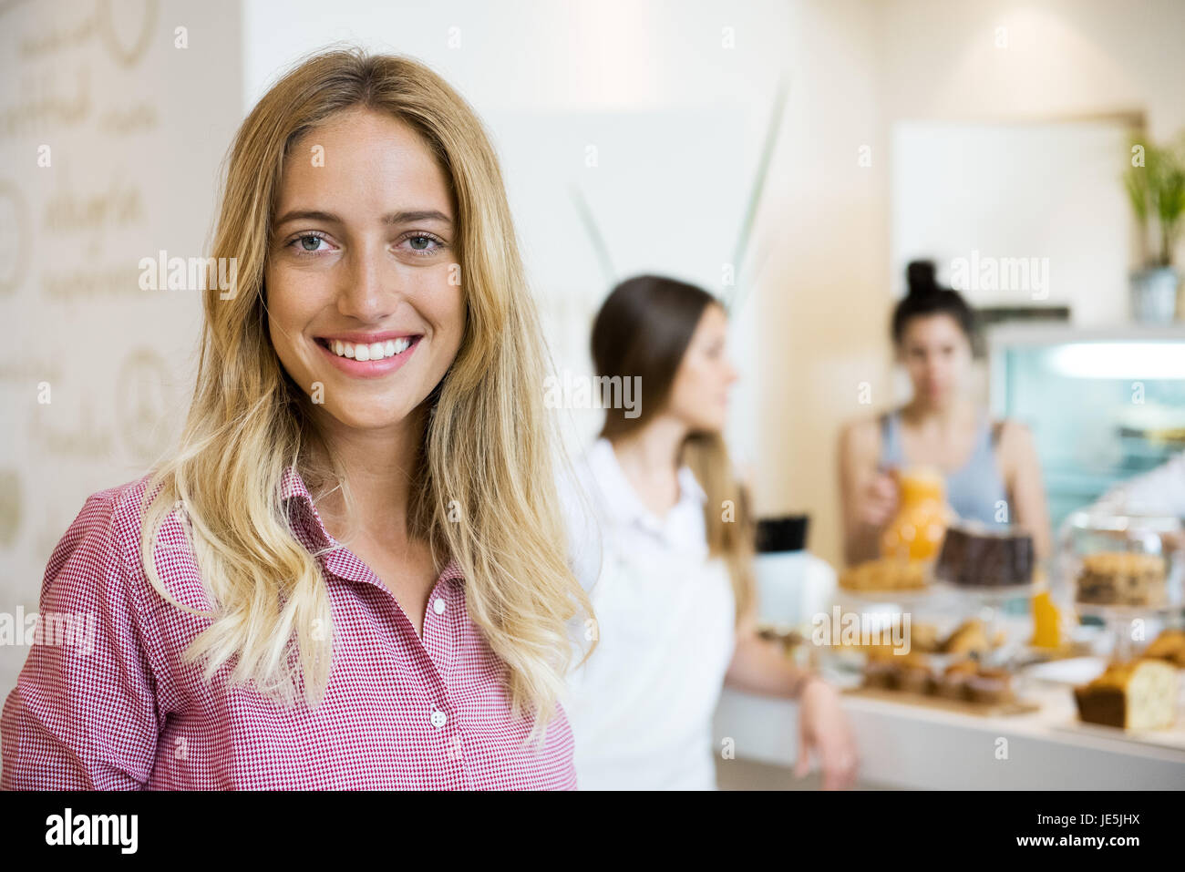 Giovane donna sorridente allegramente in small business, ritratto Foto Stock