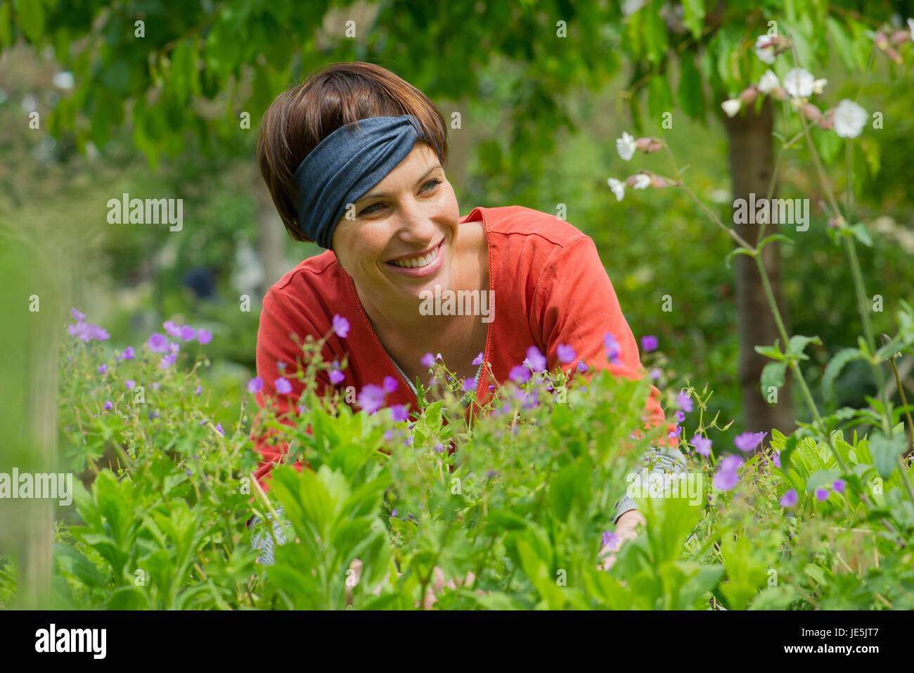 Donna sorridente in giardino Foto Stock