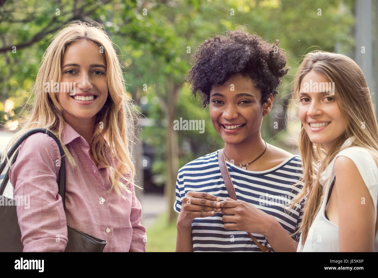 Le giovani donne a sorridere insieme all'aperto, ritratto Foto Stock