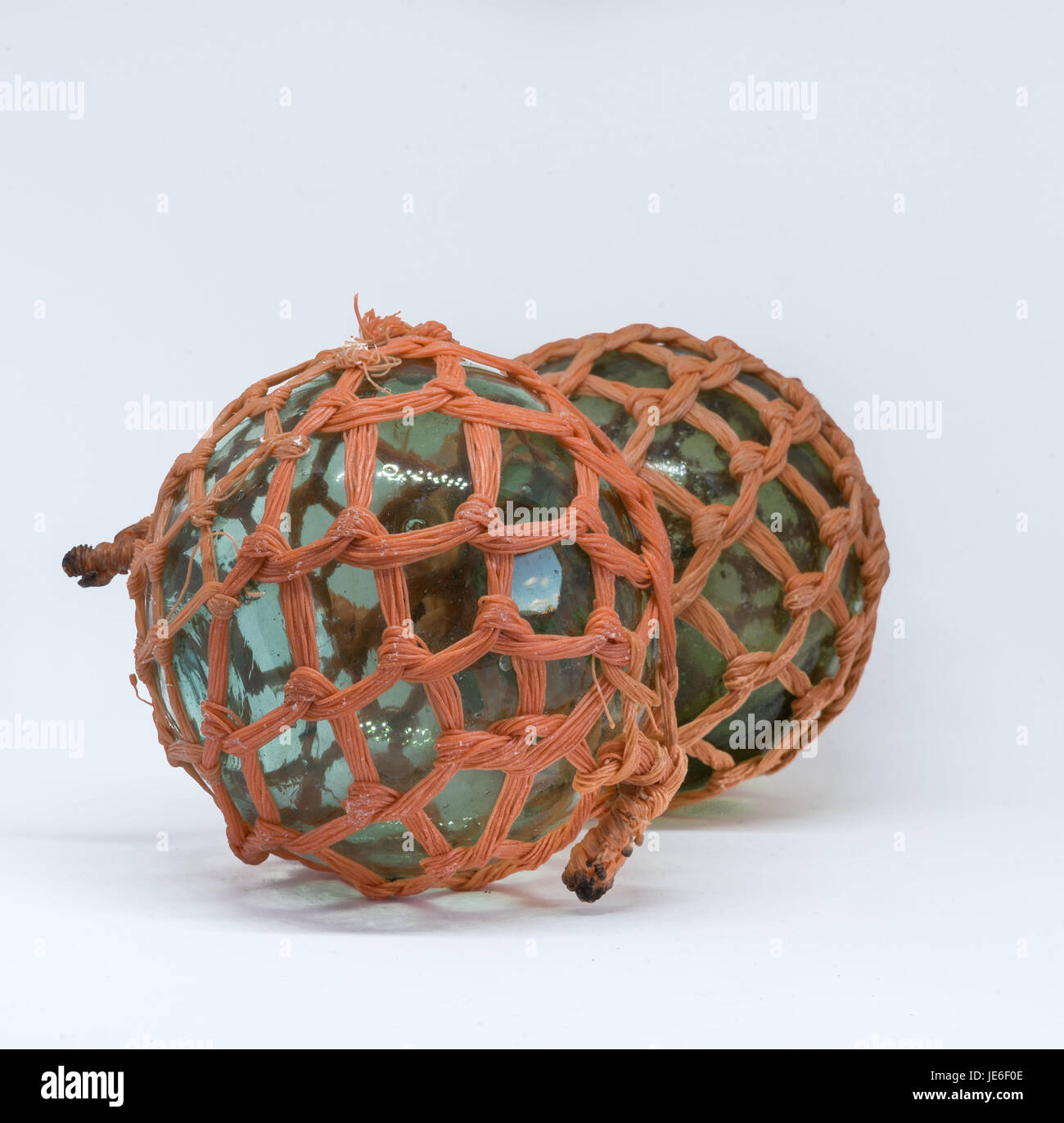 Due verdi galleggianti di vetro con il nastro arancione Foto Stock
