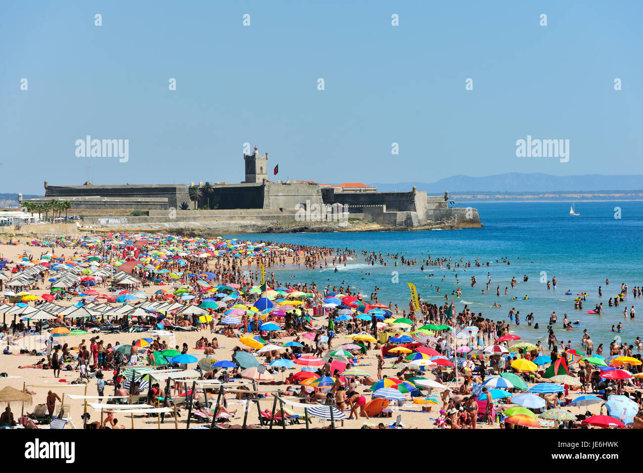 L'Agosto affollata spiaggia di Carcavelos e la fortezza di Sao Juliao da Barra, nei pressi di Lisbona. Portogallo Foto Stock