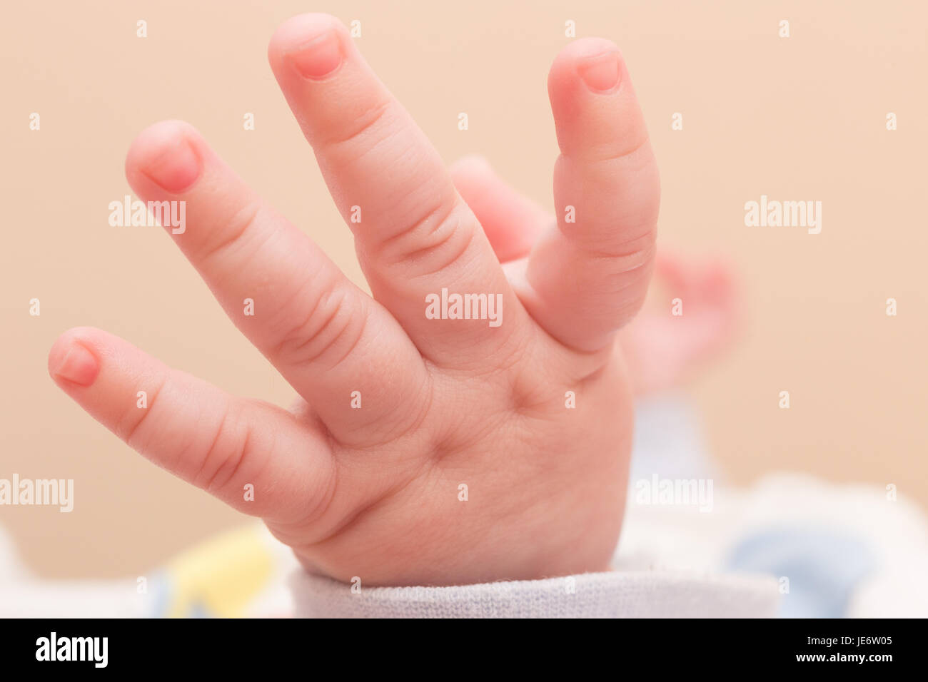 Mano di carino piccolo bambino sul letto, primo piano Foto Stock