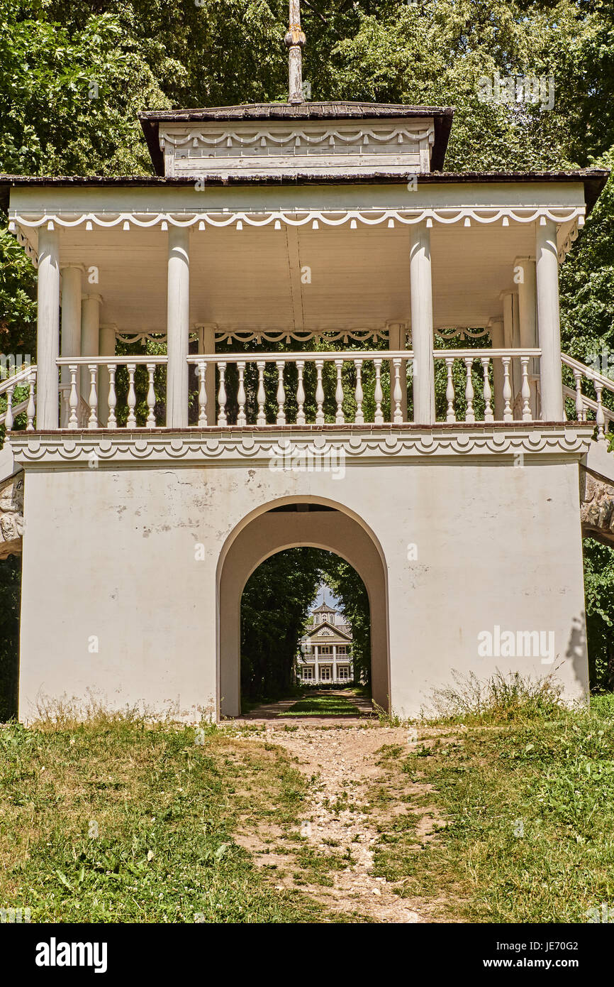 Terrazza estiva con ringhiere e scale. nell'arco di veranda è possibile vedere un edificio situato nelle profondità del parco. russia, Pskov Regione Foto Stock