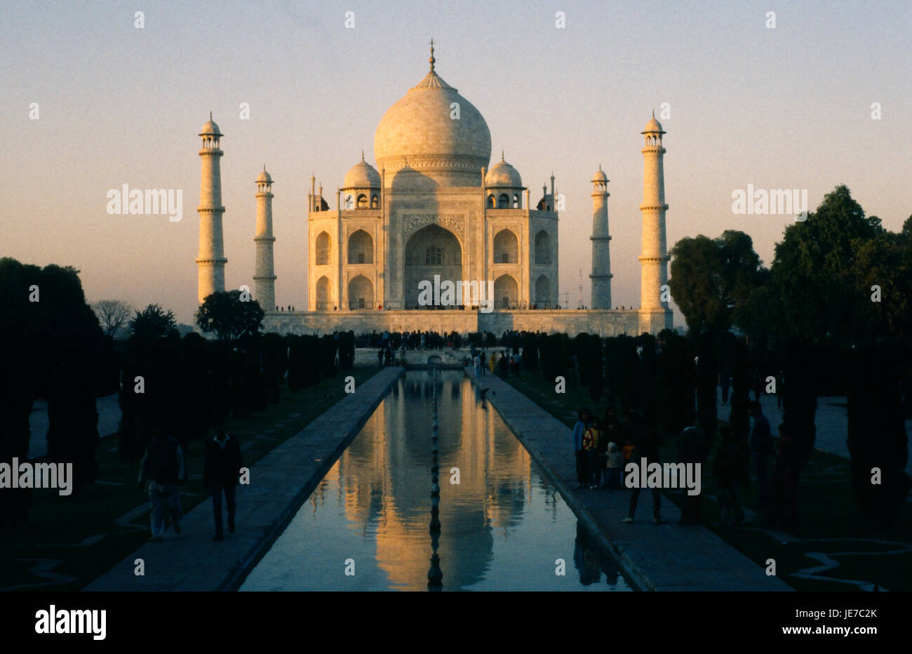 India, Uttar Pradesh, Agra il Taj Mahal di sera la luce riflessa in superficie ondulata del corso d'acqua attraverso giardini formali in primo piano con i visitatori su ciascun lato. Foto Stock