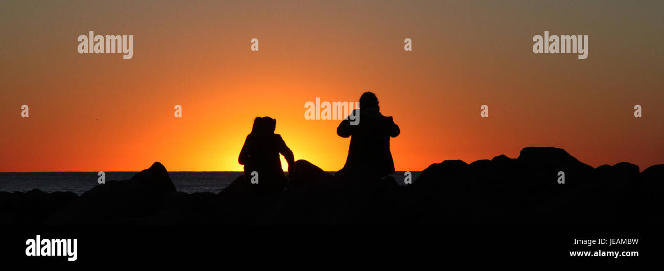 Un bellissimo tramonto di Capodanno su Morro Rock, un'importante formazione vulcanica a Morro Bay, California. La vista è una destinazione popolare per i visitatori, offrendo vedute panoramiche e un'atmosfera tranquilla a fine anno. Foto Stock