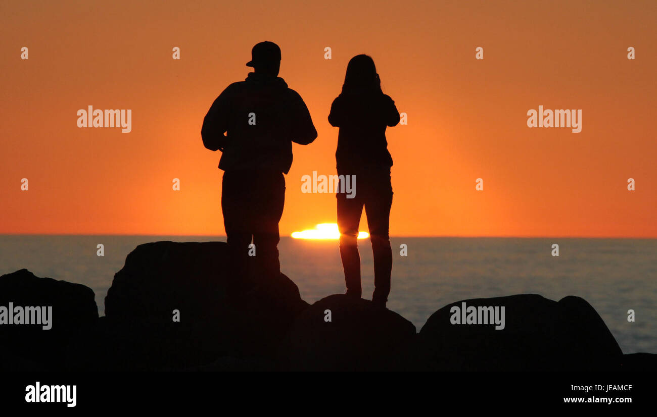 Il tramonto di Capodanno a Morro Rock, California, offre una vista mozzafiato della famosa formazione rocciosa al crepuscolo, mostrando la bellezza naturale della costa durante gli ultimi momenti dell'anno. Foto Stock