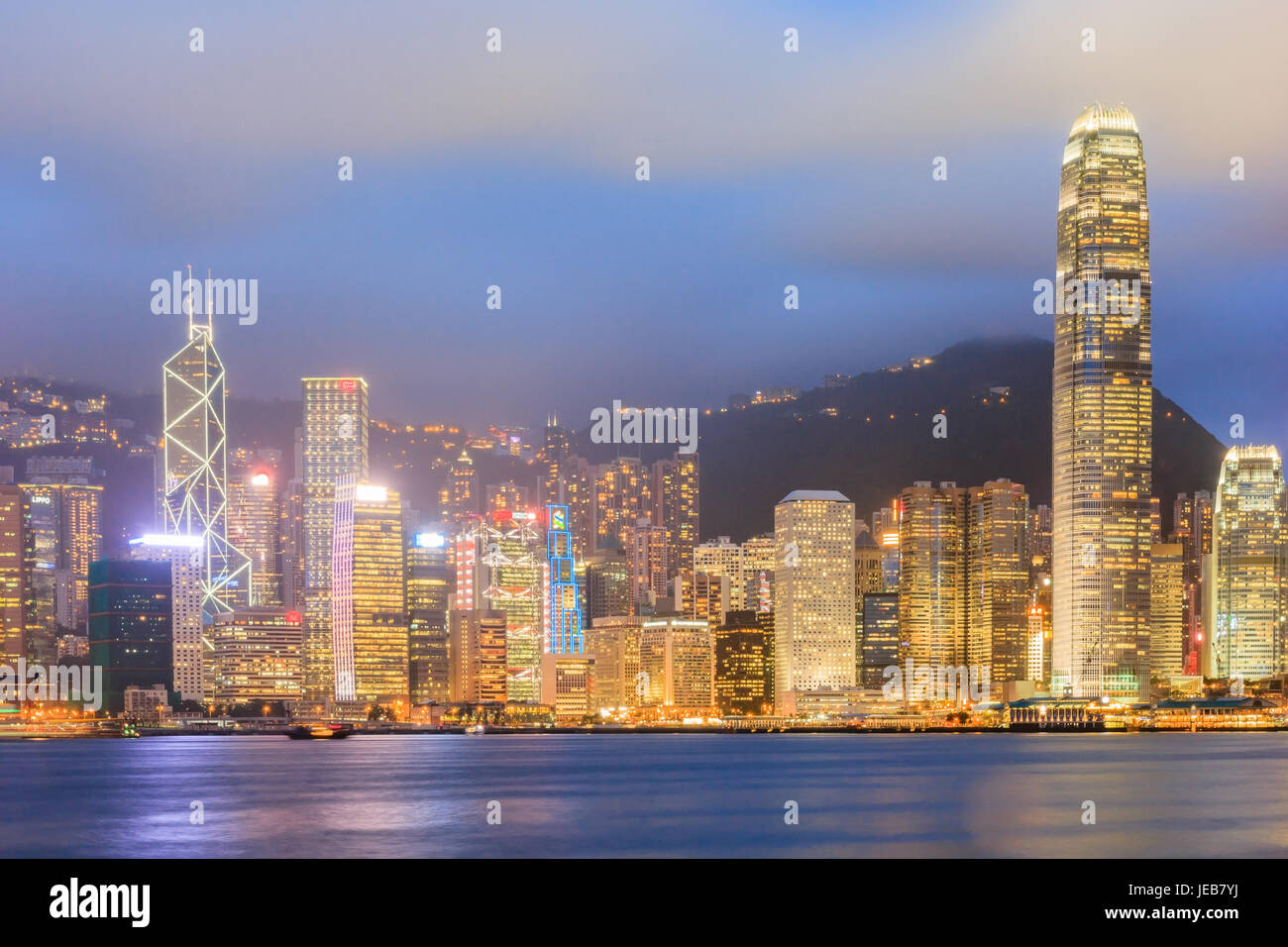 A HONG KONG, CINA - 20 Luglio: edificio di notte la luce colorata accanto a Hongkong Victoria Harbour a luglio 20, 2013 a Hong Kong, Cina. Hong Kong è una grande inter Foto Stock