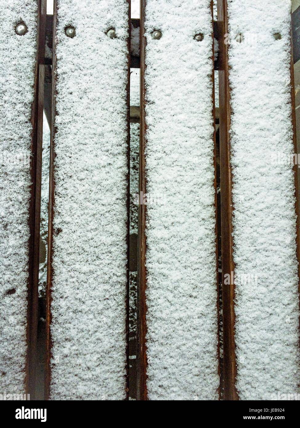 Panca di legno con neve su di esso Foto Stock