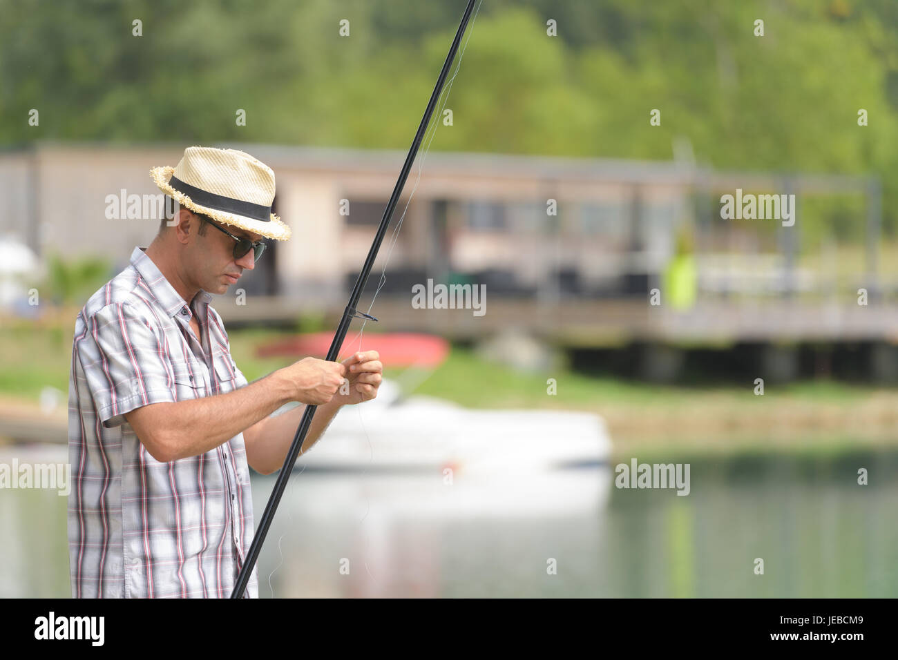 Uomo vicino al lago si prepara per la pesca Foto Stock