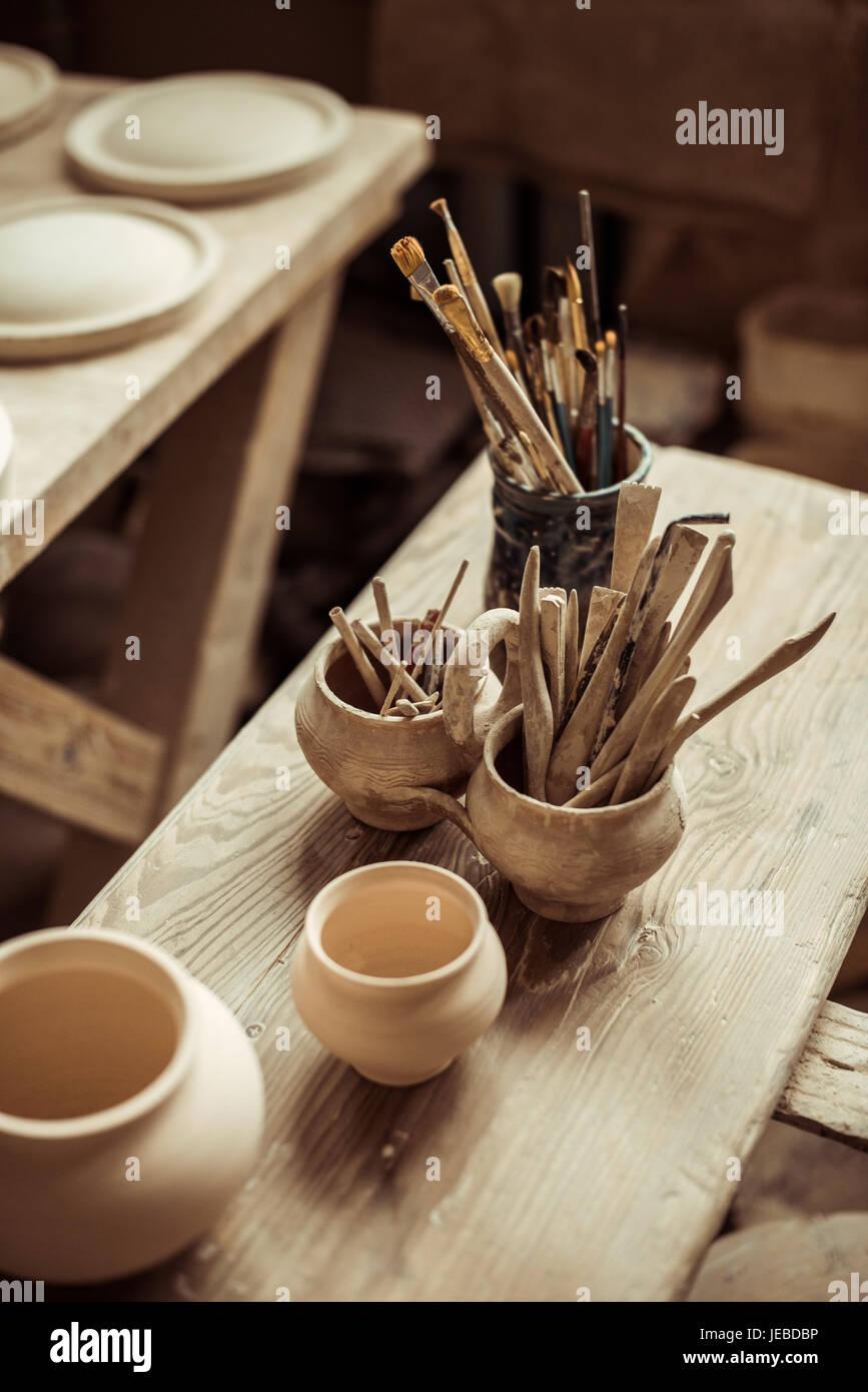 Close up di pennelli per dipingere con strumenti di ceramiche in ciotole  sul tavolo Foto stock - Alamy