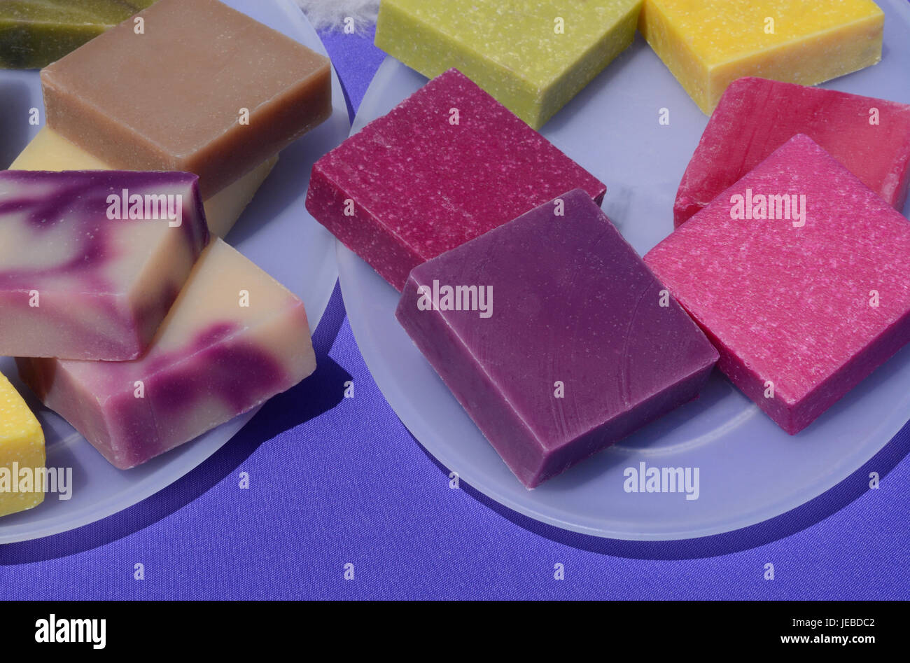 Colorata a mano sapone di cera d'api piazze su piastre Foto Stock