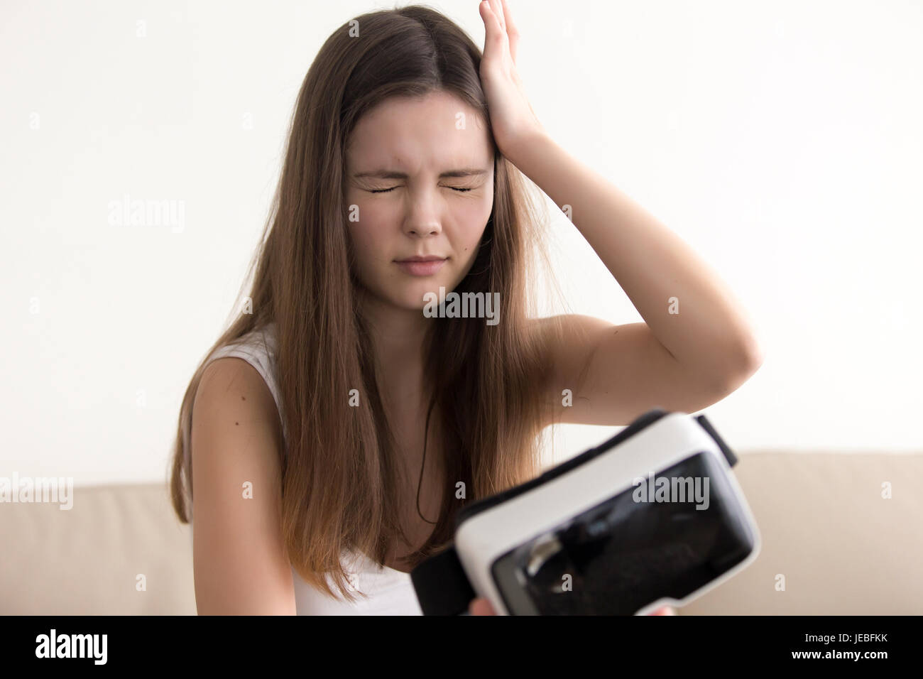 Signora sente vertigini dopo utilizzando occhiali VR Foto Stock