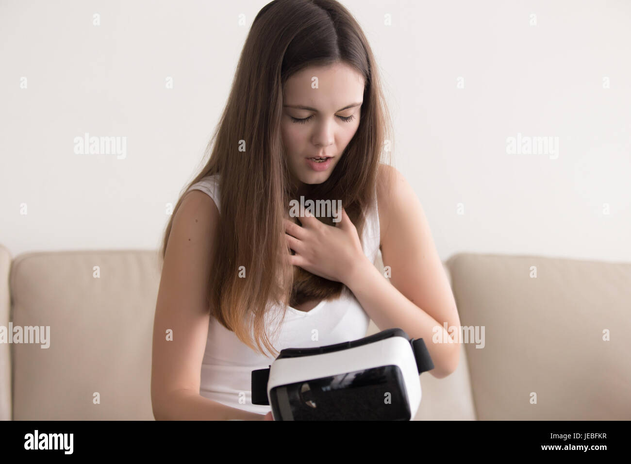 Donna cerca di calmare giù dopo utilizzando occhiali VR Foto Stock