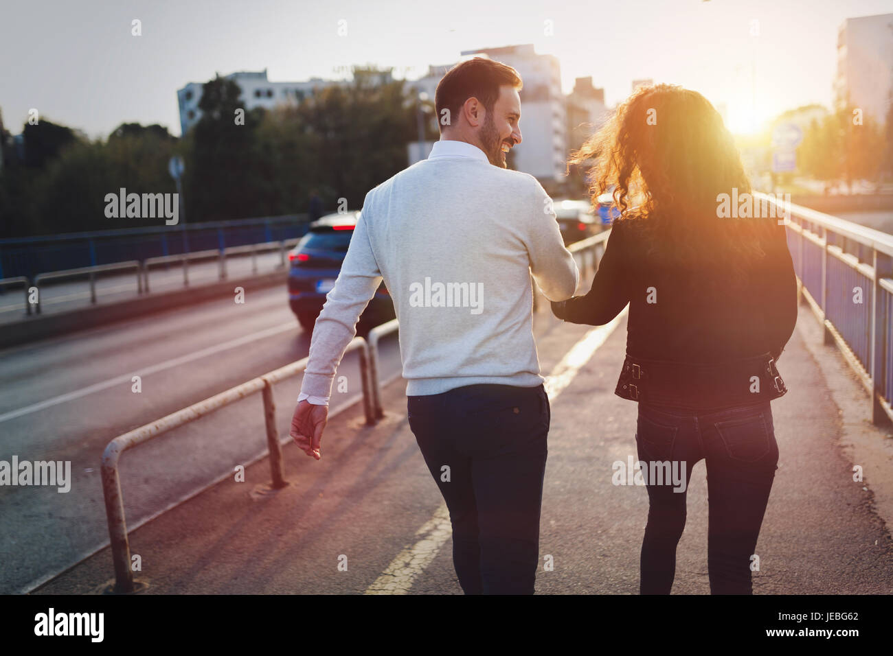 Felice coppia giovane camminando mano nella mano Foto Stock