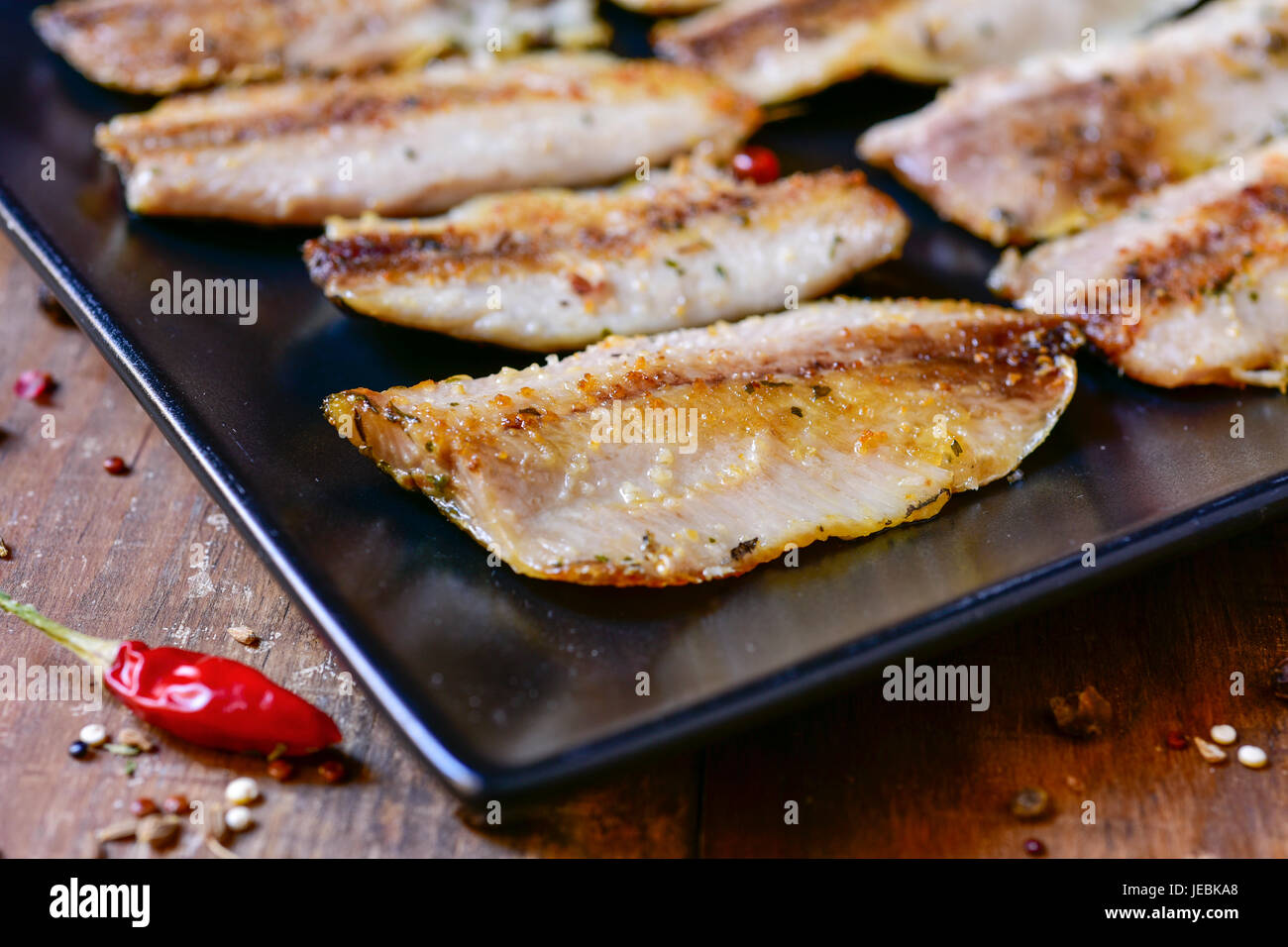 Ingrandimento di una piastra con un po' di spagnolo di filetti di sardine è servita come tapas, su una tavola in legno rustico Foto Stock
