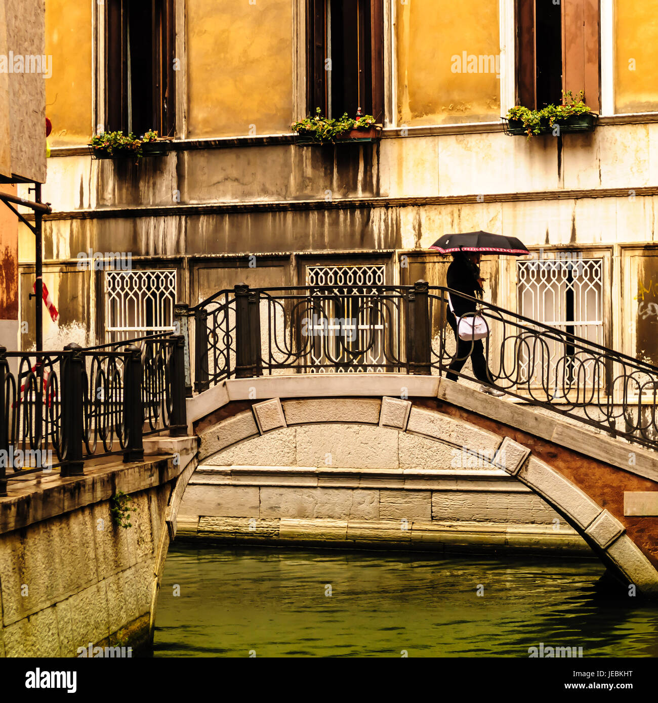 Le donne a piedi sul ponte sotto la pioggia a Venezia in Italia. Uno dei molti piccoli ponti di Venezia. Il nostro primo giorno a Venezia pioveva, era ancora molto grande Foto Stock