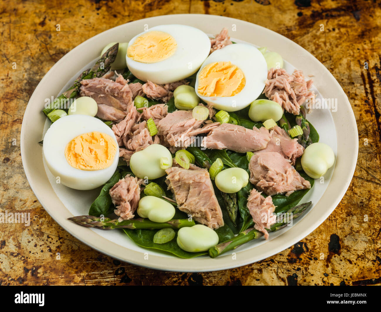 Tonno con insalata di fave uova sode e asparagi seduto su una teglia da forno Foto Stock