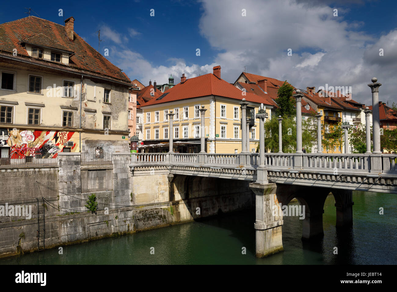 Colonne sul Plecnik progettato Cobblers ponte sopra il fiume Ljubljanica con antico e ristrutturato case Ljubljana Slovenia Foto Stock