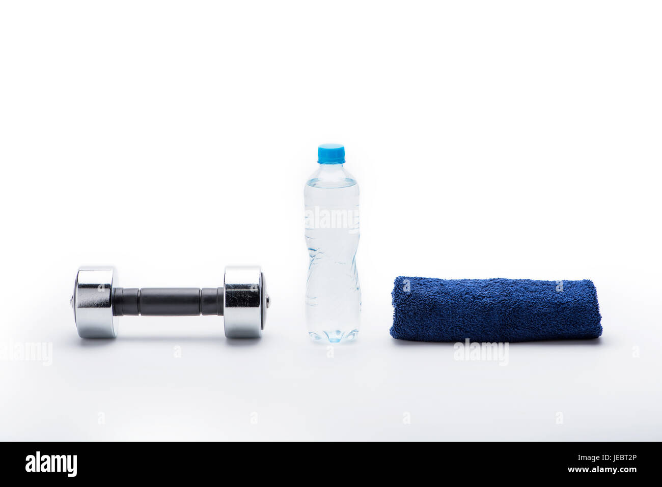 Manubrio metallico, asciugamano e una bottiglia con acqua isolato su bianco. Le attrezzature di sport e di uno stile di vita sano concetto Foto Stock
