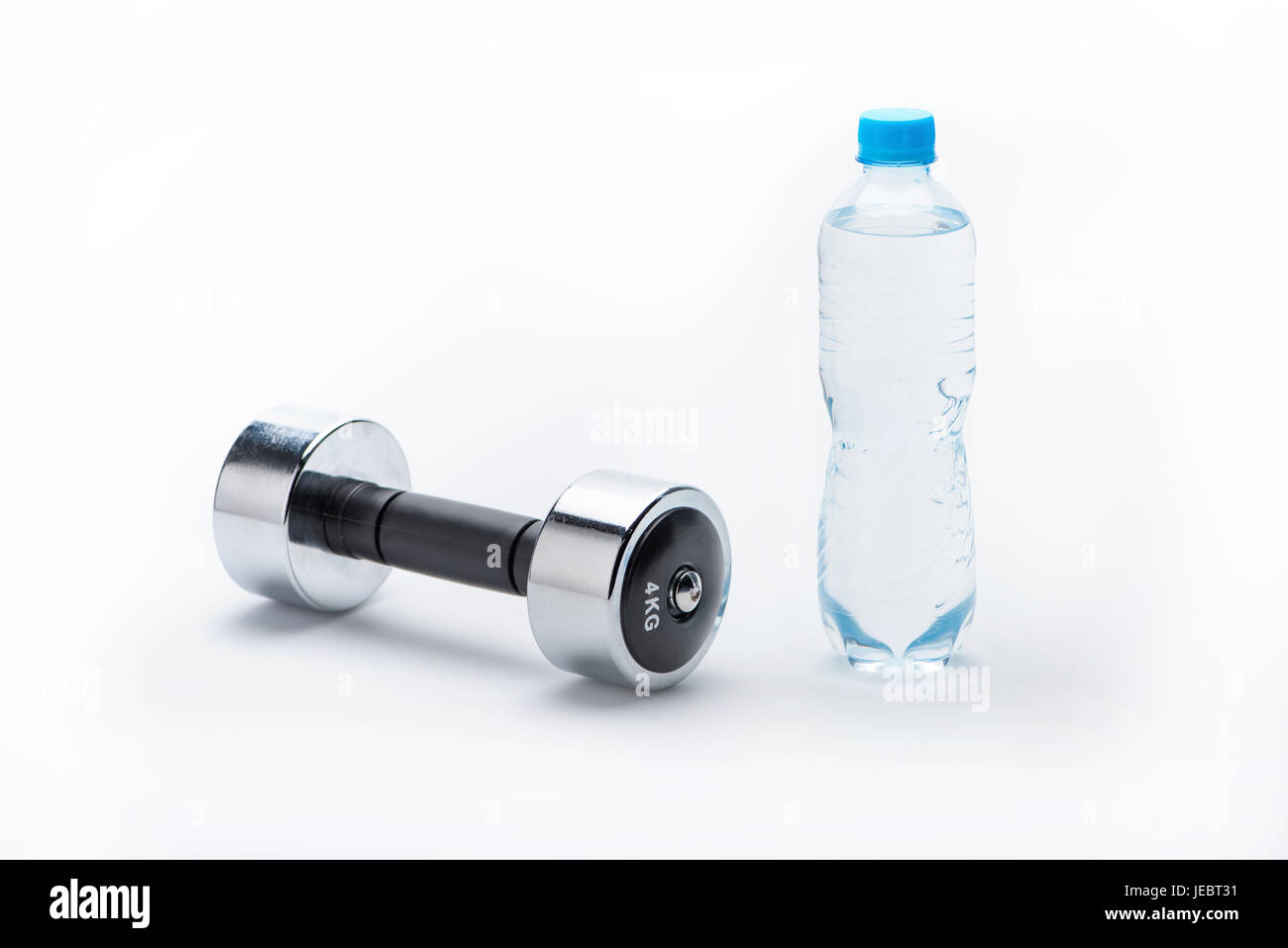 Manubrio metallico e una bottiglia con acqua isolato su bianco. Bere acqua, attrezzature sportive e uno stile di vita sano concetto Foto Stock