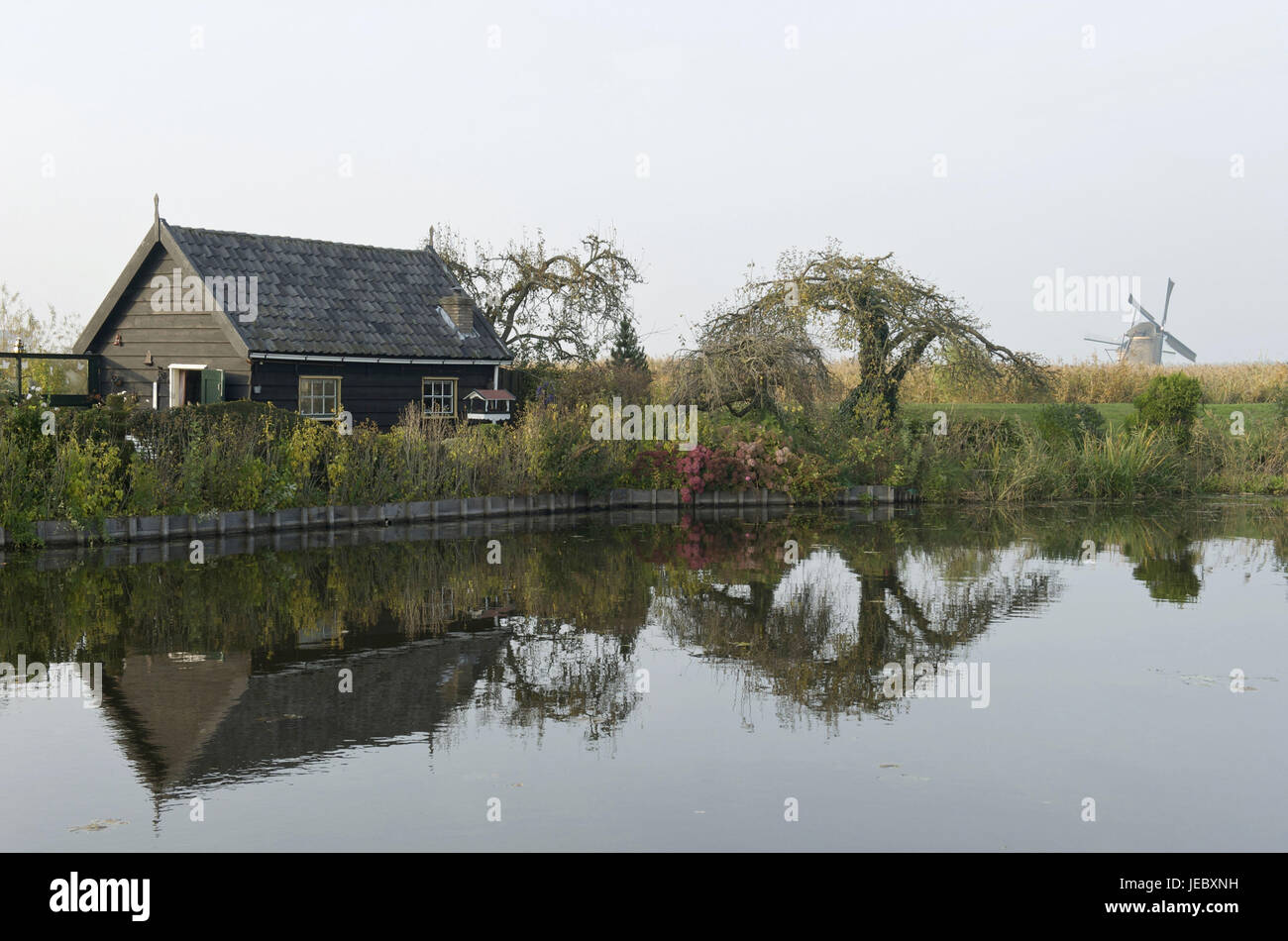 Holland, Paesi Bassi, provincia di Nordholland, Kinderdijk, casa nel canale in background di mulini a vento, Foto Stock