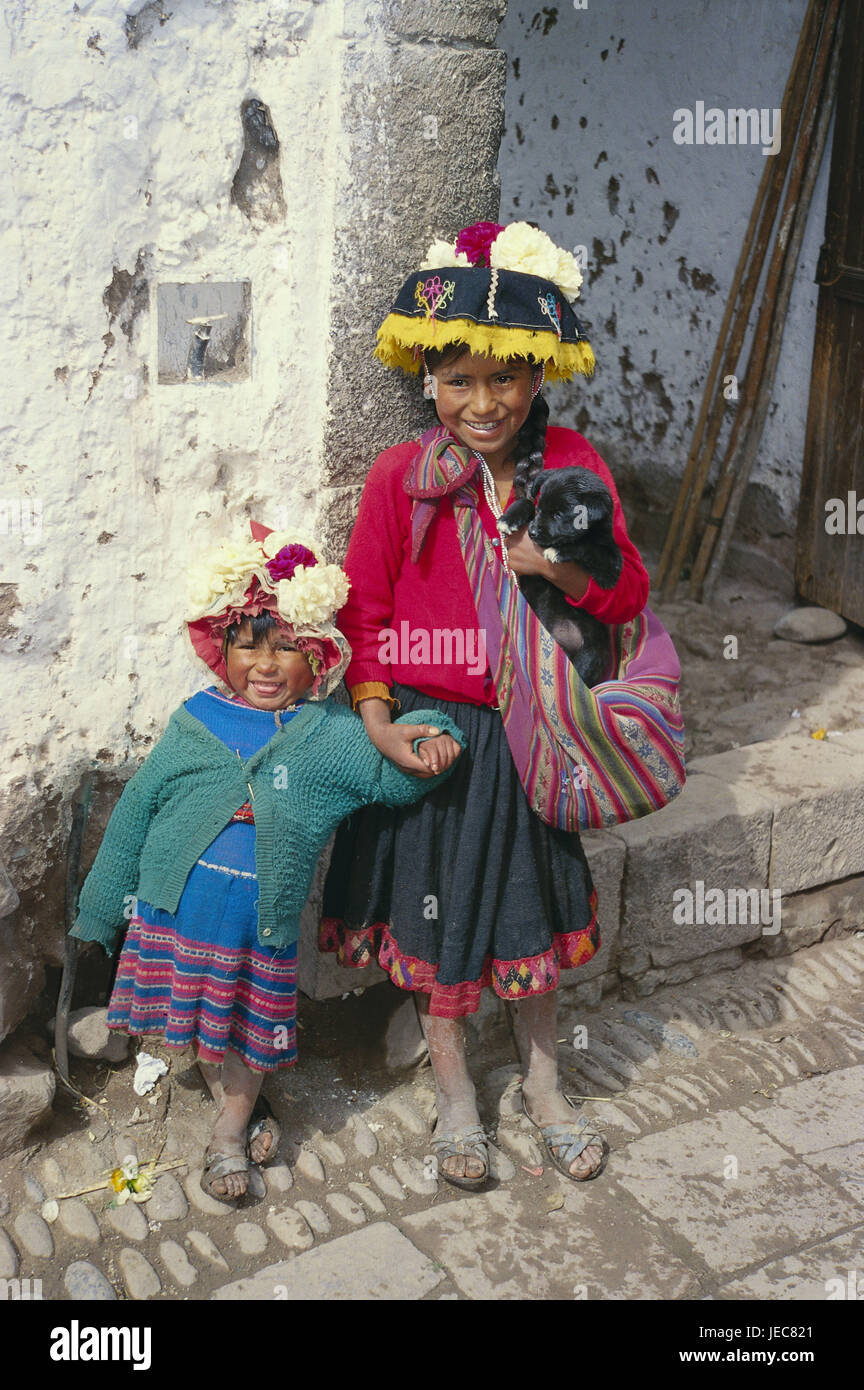 Il Perù, Pisaq, bambini, bambine, felicemente, Sud America, persona, locali, South American Indian's ragazze, sorelle, vestiti, luminosamente, colorfully, tipicamente per paese, cappelli, headgears, pet, cane, cucciolo, trasportare, ridere, infanzia, illuminante, icona, destinazione, turismo, povertà, frugalità, Foto Stock