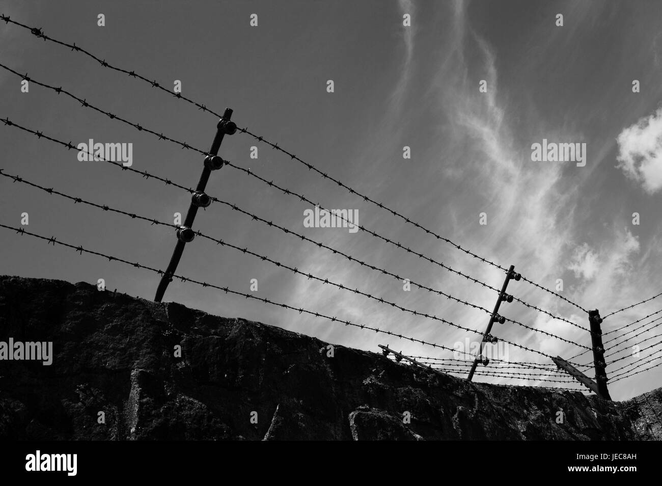 Austria, Mauthausen, campo di concentramento memorial, accerchiamento muraglia difensiva, filo spinato, spazio esterno, cielo nuvoloso, s/w, Austria superiore, campo di concentramento, il socialismo nazionale, campo di lavoro, campo di concentramento, campo di prigionia, detenuto dal magazzino, del prigioniero di guerra del magazzino, supporto, omicidio, distruzione, omicidio, duro lavoro, la Shoah, dimensione omicidio, la distruzione di massa, l'antisemitismo, dei prigionieri di guerra, gli ebrei, zingari, memorial, raccoglimento, promemoria, Memorial, il filo spinato, mura difensive, recinto, il blocco, la disperazione, certamente circa epidemia, nessuno, all'esterno, Foto Stock