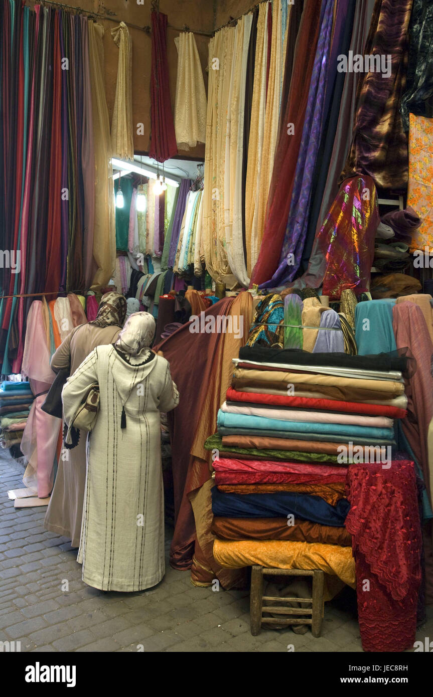 Il Marocco Marrakech, Souk, vendite, sostanze, donne, fare acquisti, Africa, Nord Africa, destinazione, luogo di interesse, cultura, commercio, commercio al dettaglio, economia, mercato, prodotti tessili, sostanza balle, sostanza traiettorie, persone locali, caftan, vista posteriore, stand, Foto Stock