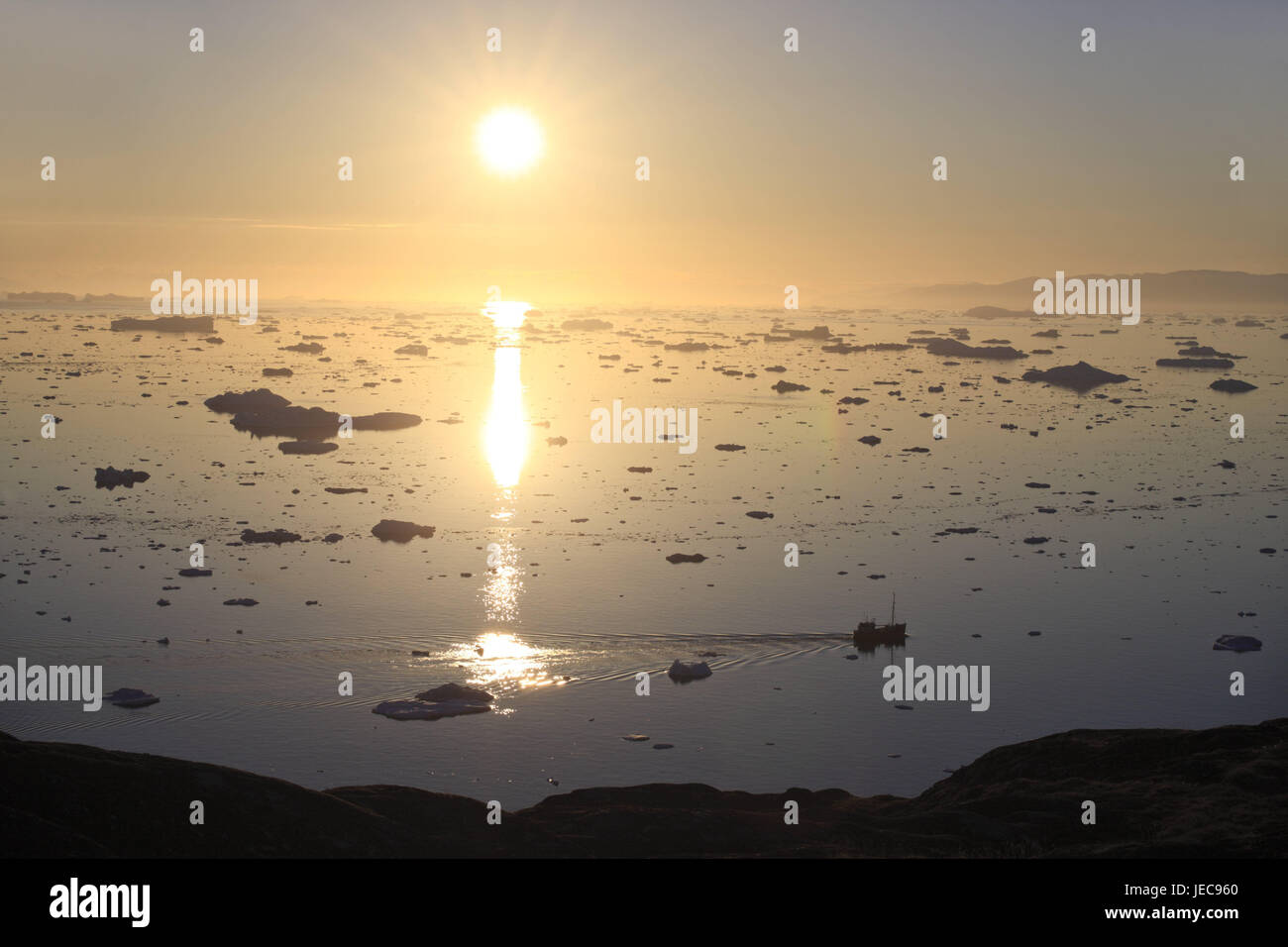 La Groenlandia, Discoteca Bay, Ilulissat, Fjord, drift ice, visualizzare il sole di mezzanotte, luce posteriore, Groenlandia occidentale, ghiaccio, ghiacciaio, ghiacciaio, l'Artico, estate, solitudine, deserte, ghiacciaio terminazione anomala, natura, cambiamenti climatici, mirroring, superficie di acqua, costa, barca, il sole, Foto Stock