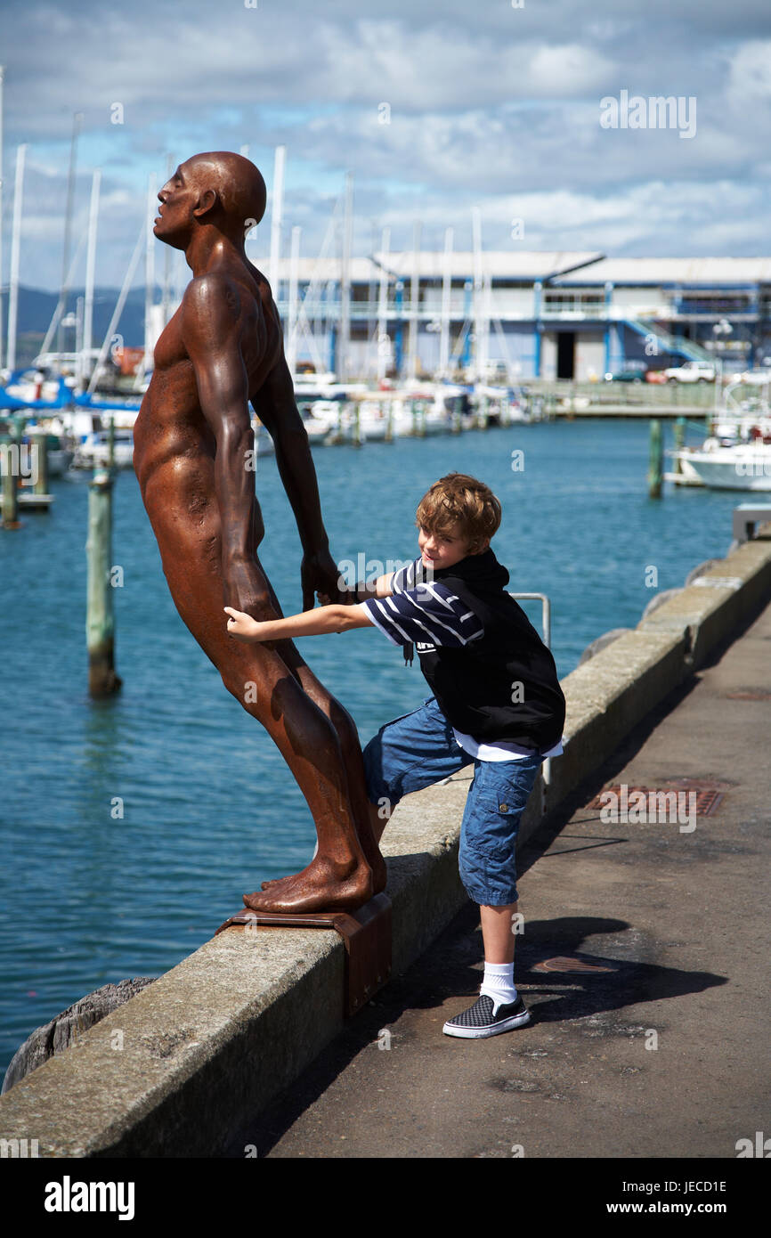 Ragazzo (12) iteracting con Wellington waterfront Max patte, scultura, conforto nel vento Foto Stock