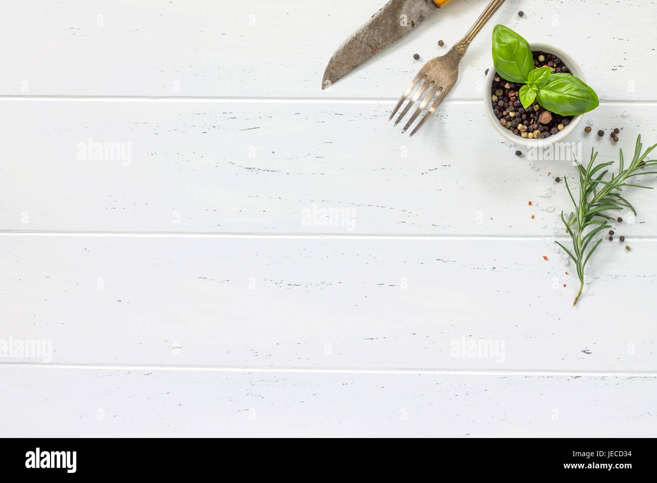 Legno bianco tavolo da cucina. Sullo sfondo la cucina con le erbe aromatiche e le spezie, copia spazio, vista dall'alto. Foto Stock