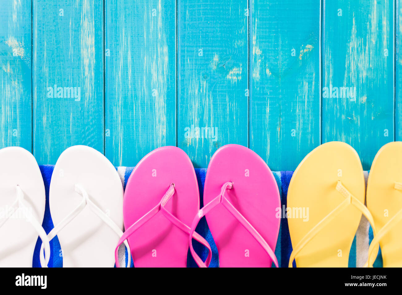 Luminose donna infradito con telo da spiaggia. Foto Stock