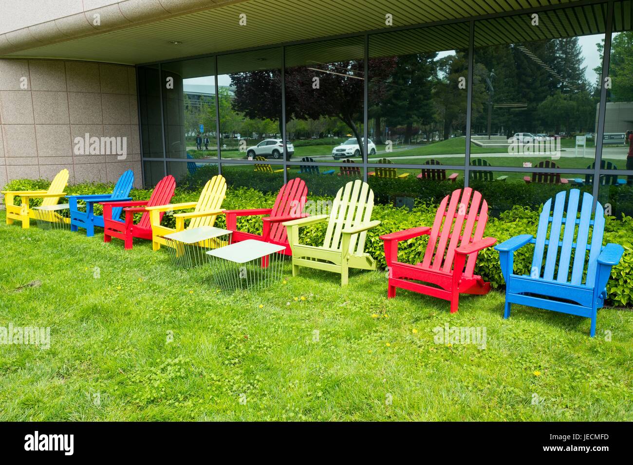 Colorate sedie Adirondack in Google Inc colori del marchio presso il Googleplex, quartier generale di Google Inc di Silicon Valley Town di Mountain View, California, 7 aprile 2017. Foto Stock