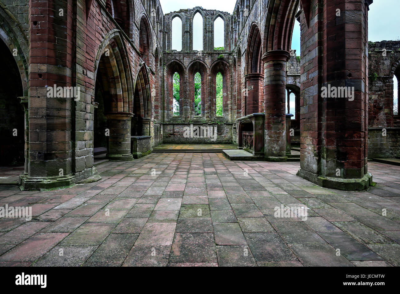 Archi di pietra, colonne e windows, rovine di Lanercost Priory, North Brampton, Cumbria, England, Regno Unito Foto Stock