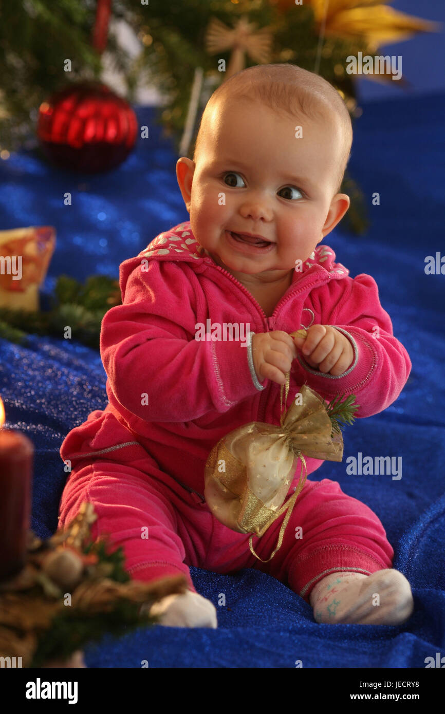 Baby, 6 mesi, sedersi, albero di Natale, skyer, presenta grandi occhi, Foto Stock