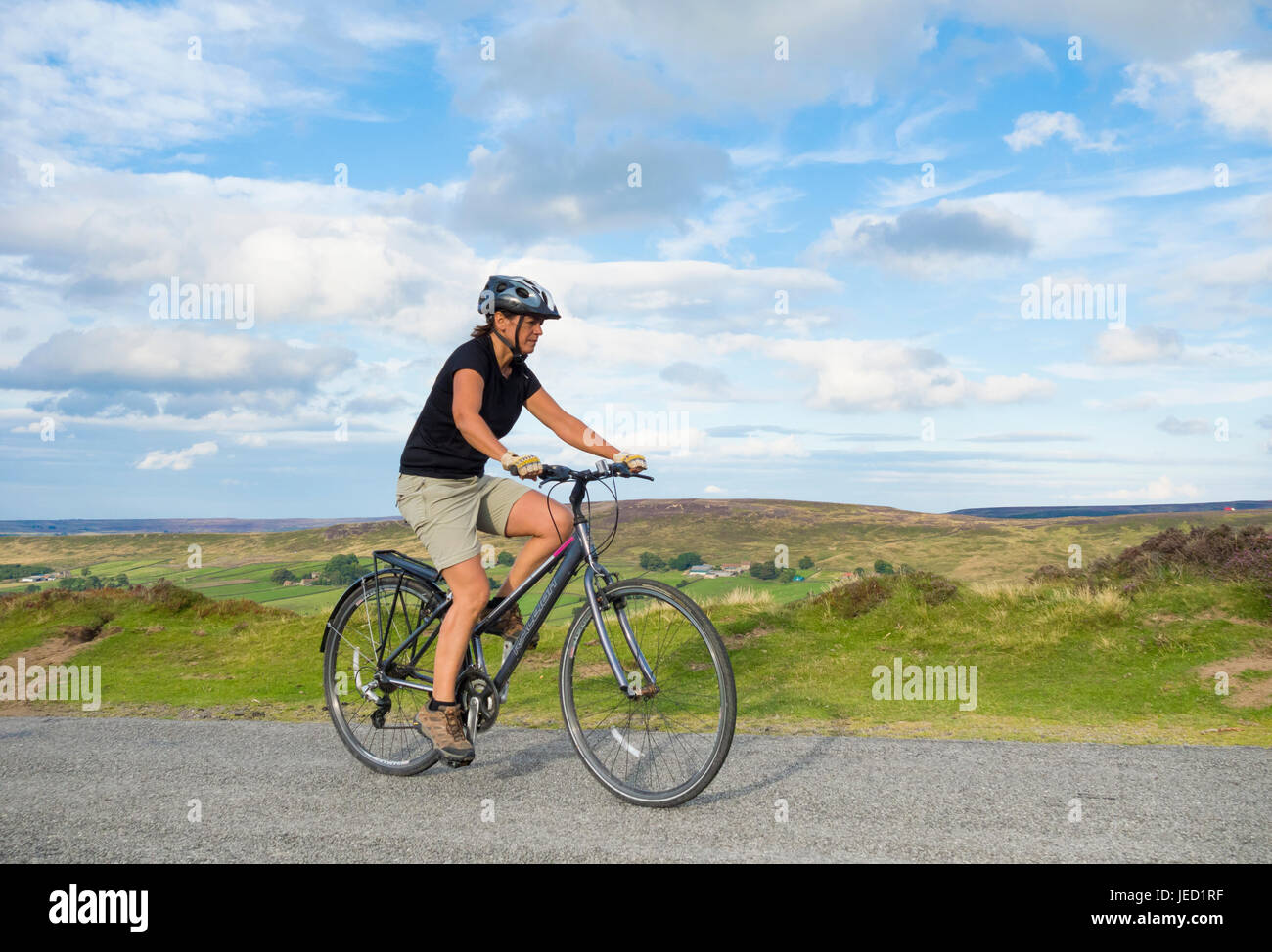 Ciclista femmina vicino westerdale nel North York Moors National Park. North Yorkshire, Inghilterra. Regno Unito Foto Stock
