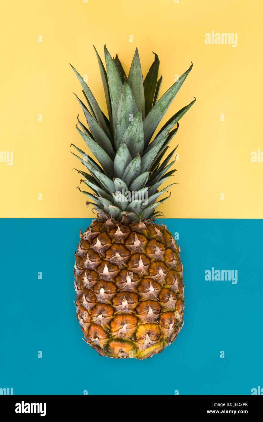Ananas vicino fino a metà metà giallo sfondo blu Foto Stock